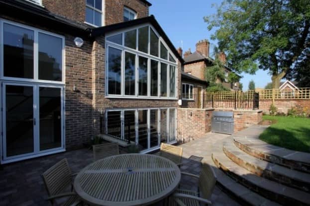 a patio with a table and chairs next to a building.